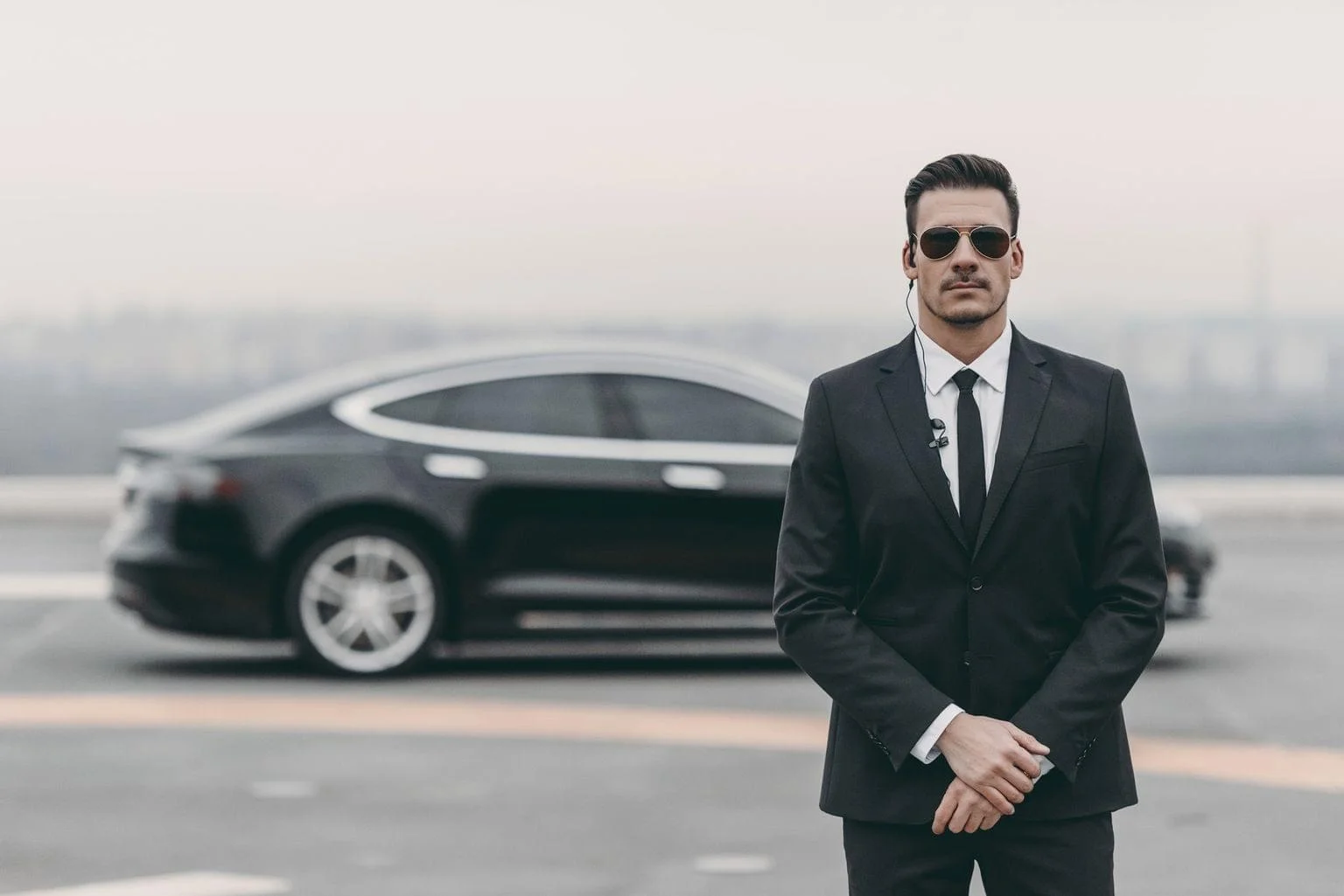 serious-bodyguard-standing-with-sunglasses-and-security-earpiece-on-helipad-1.jpg.bv_resized_desktop.jpg.bv